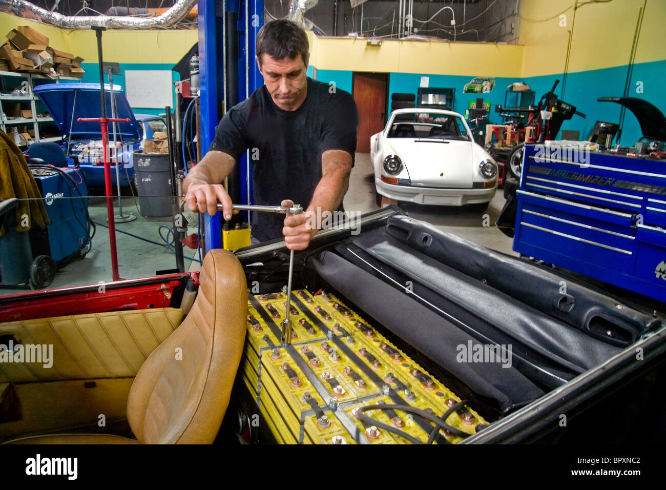 Ein Techniker in einem Southern California Fahrzeug Modifikation Shop installiert 335-Volt DC Lithium Eisen Phosphat (LiFePO4) Akku Stockfoto