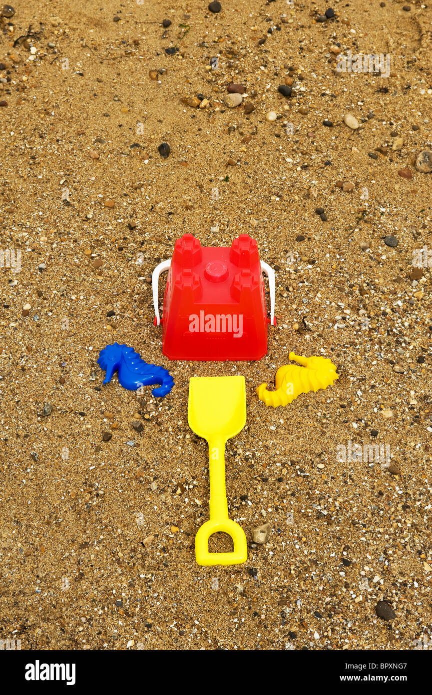 Bunte Kunststoff-Eimer und Spaten an einem Strand. Stockfoto