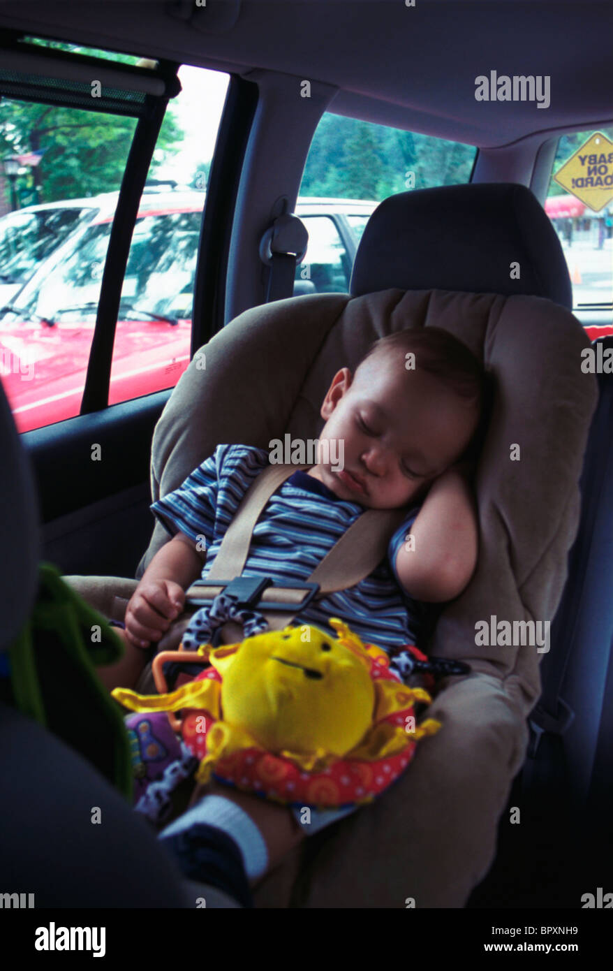 Junge, Nickerchen im Autositz Stockfoto