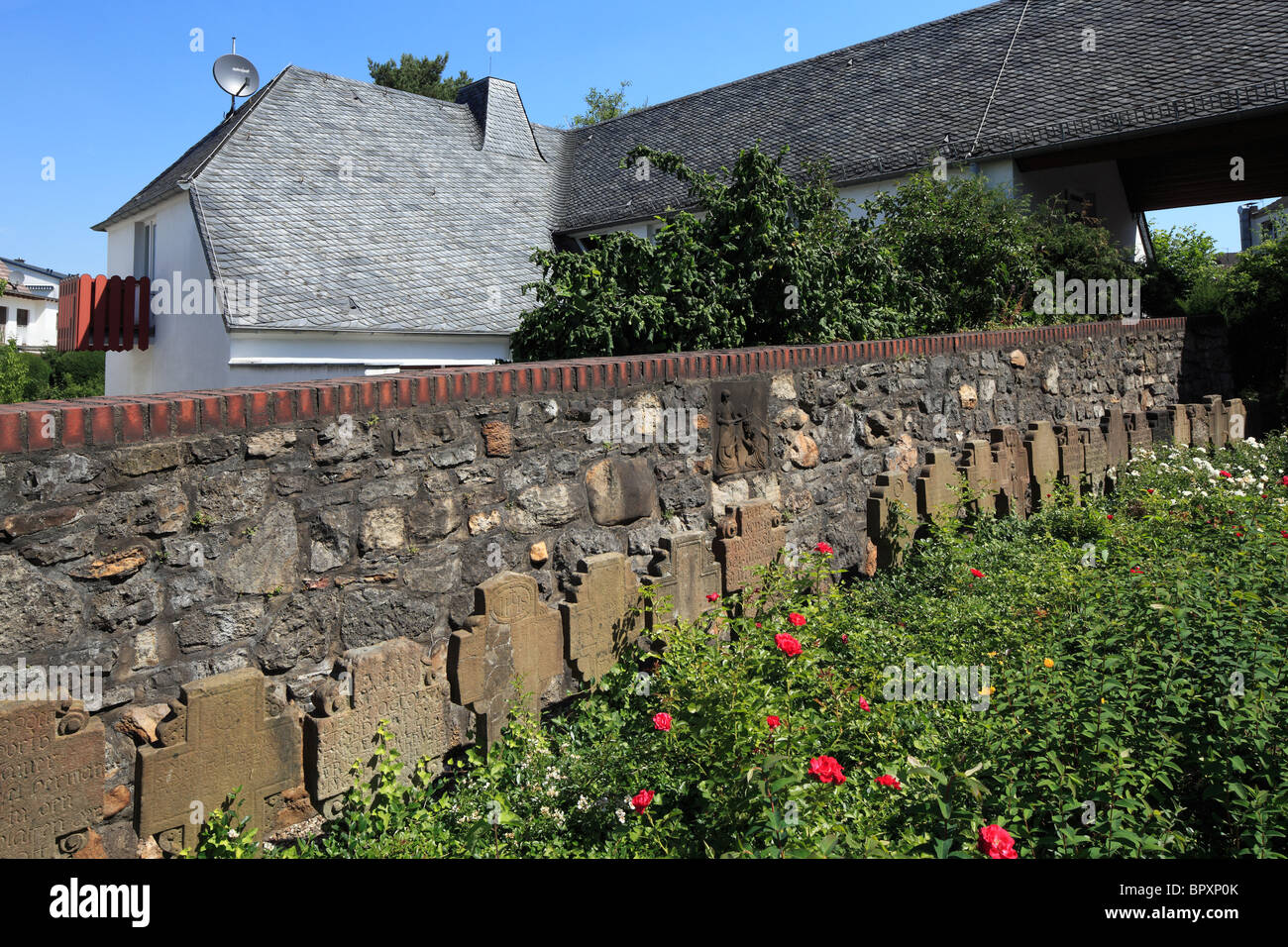 Historische Grabkreuze eine der Kirchenmauer der Katholischen Pfarrkirche St. Clemens in Paffrath, Bergisch Gladbach, Bergisches Land, Nordrhein-Westfal Stockfoto