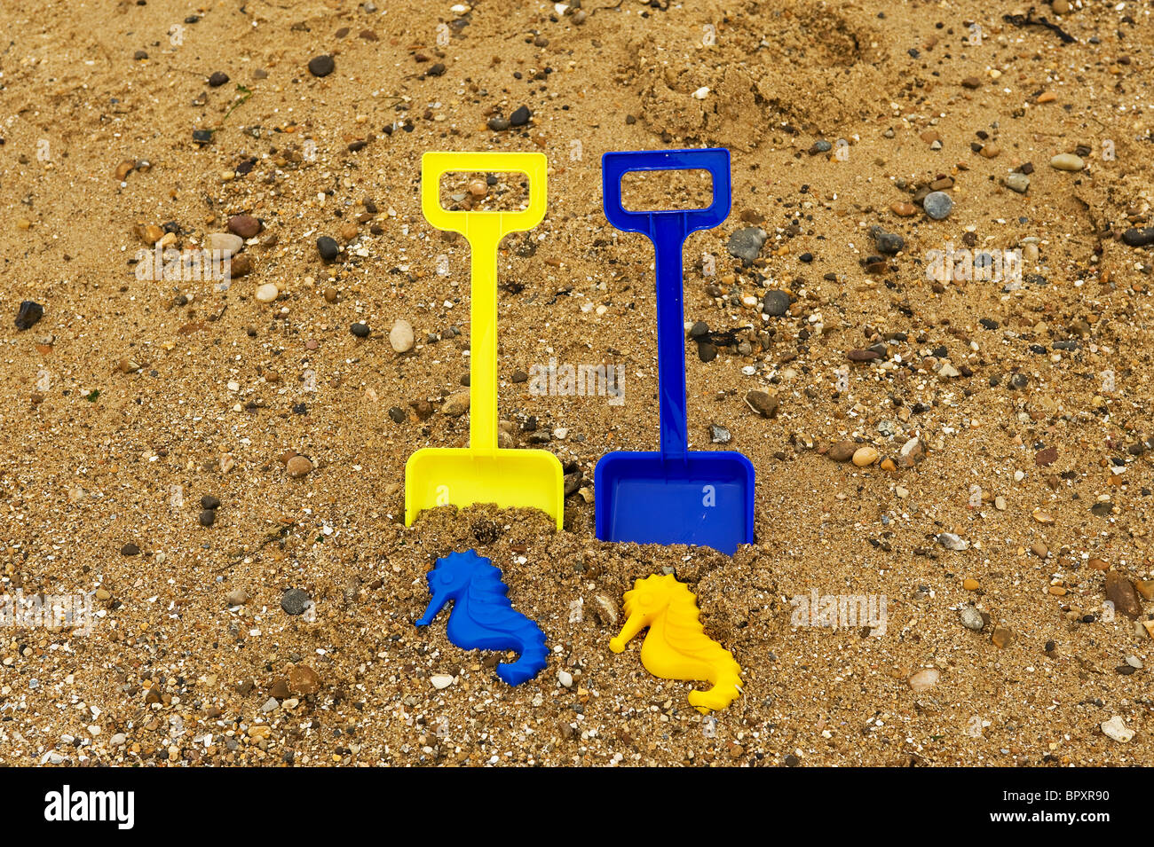 Kunststoff-Pik und Spielzeug an einem Strand. Stockfoto