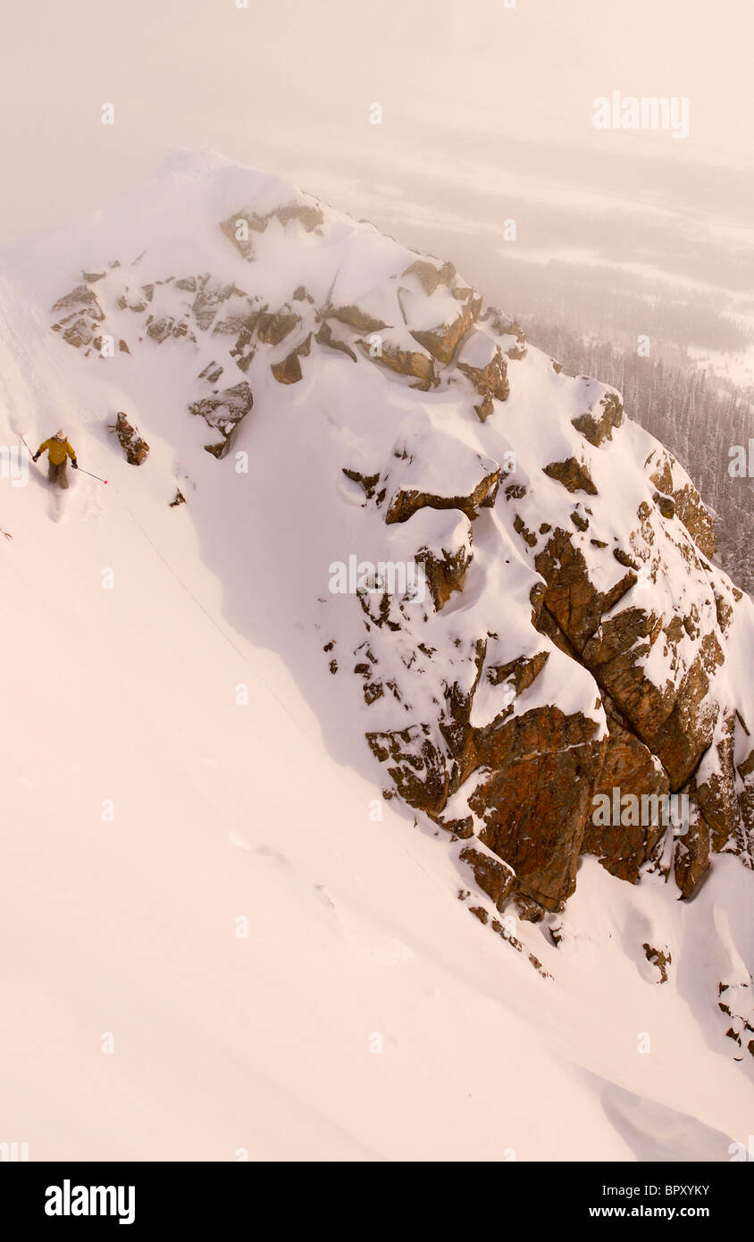 Ein Skifahrer fällt in die Klippen in der Nähe von Jackson Hole Mountain Resort in Jackson Hole Backcountry. Stockfoto