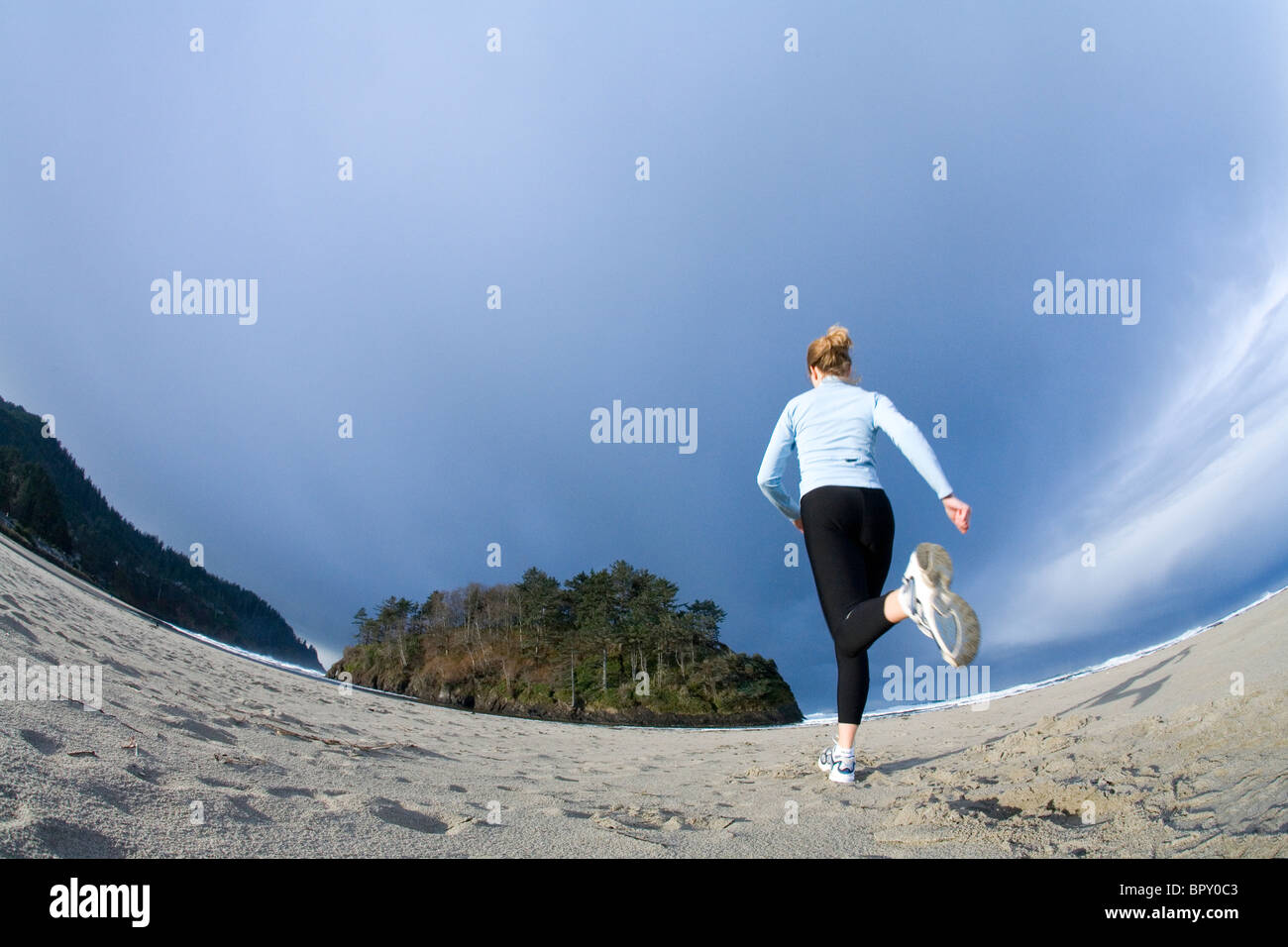 Eine Frau trainiert an der Küste. Stockfoto