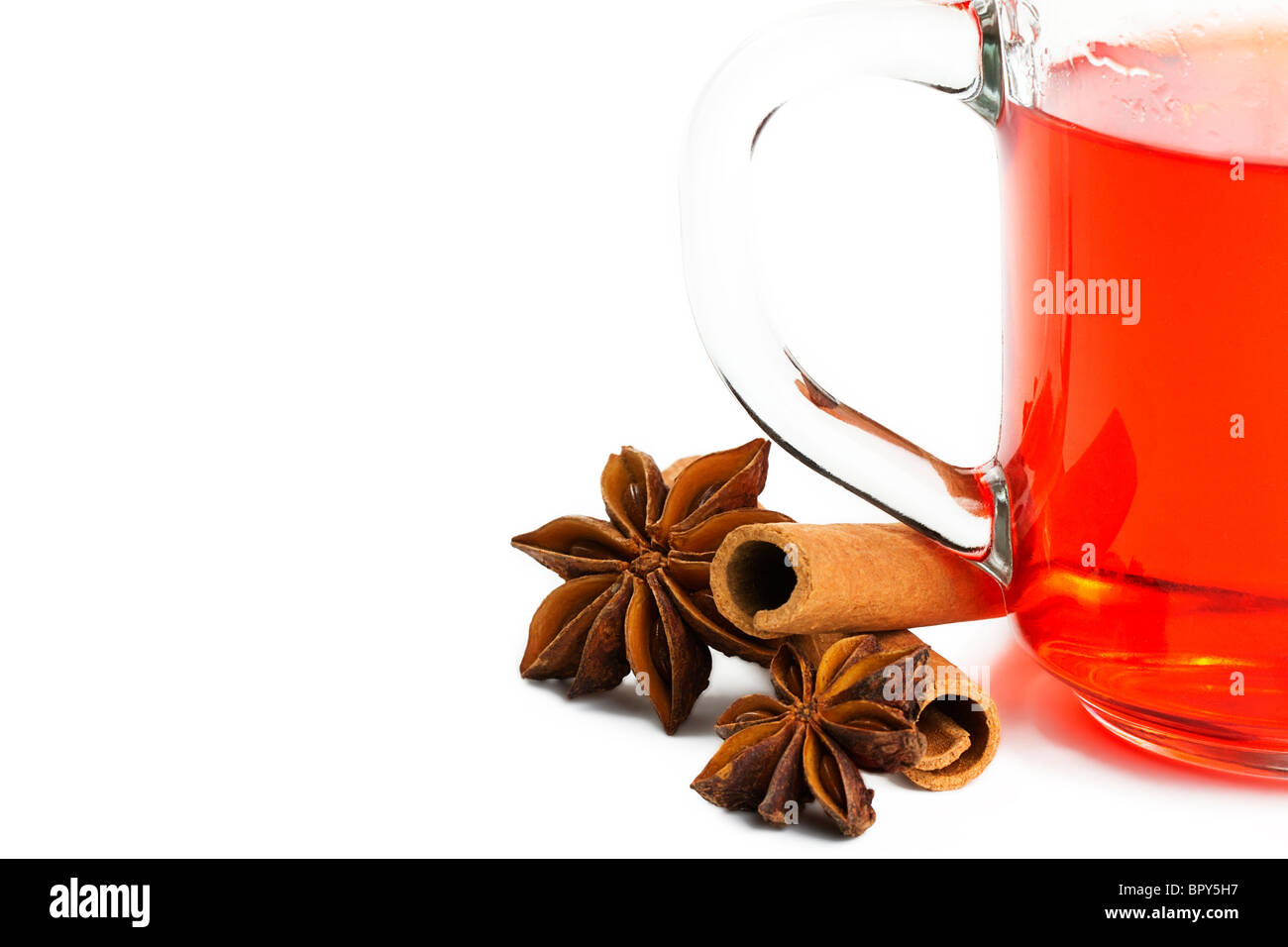 eine halbe rote Tee mit Zimtstangen und Sternanis auf weißem Hintergrund Stockfoto