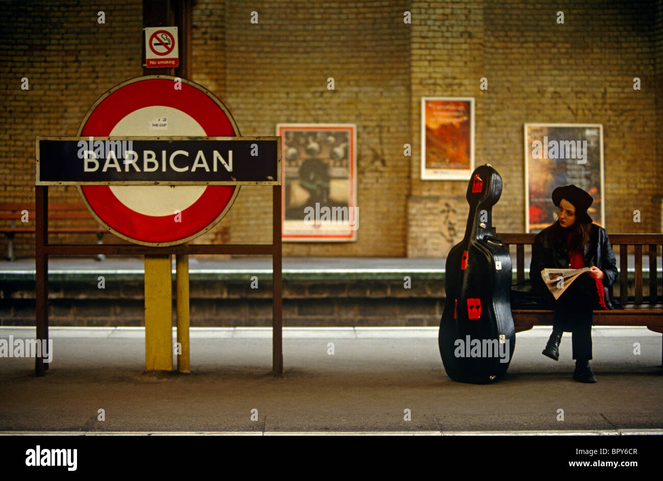 Ein Dame Musiker mit ihrem Cello sitzt am Barbican u-Bahn-Station im Zentrum von London. Stockfoto