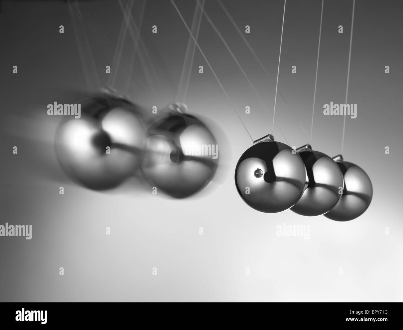 Newtons Wiege mit fünf Metallkugeln auf grauem Hintergrund. Newtons Pendel in Aktion, bewegter Metall Sphären Stockfoto