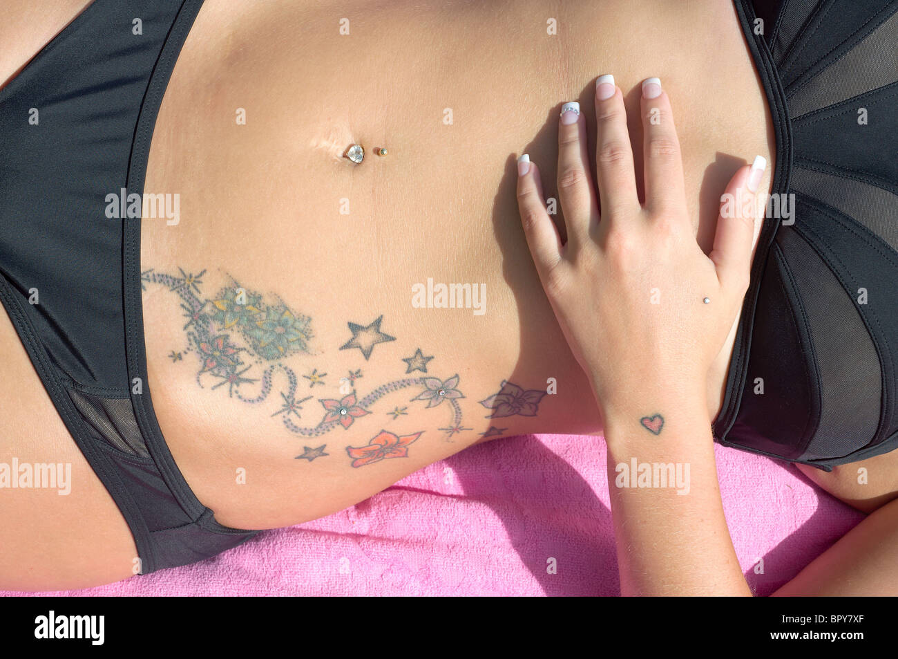 Tattoos und Juwel im Bauchnabel Stockfoto