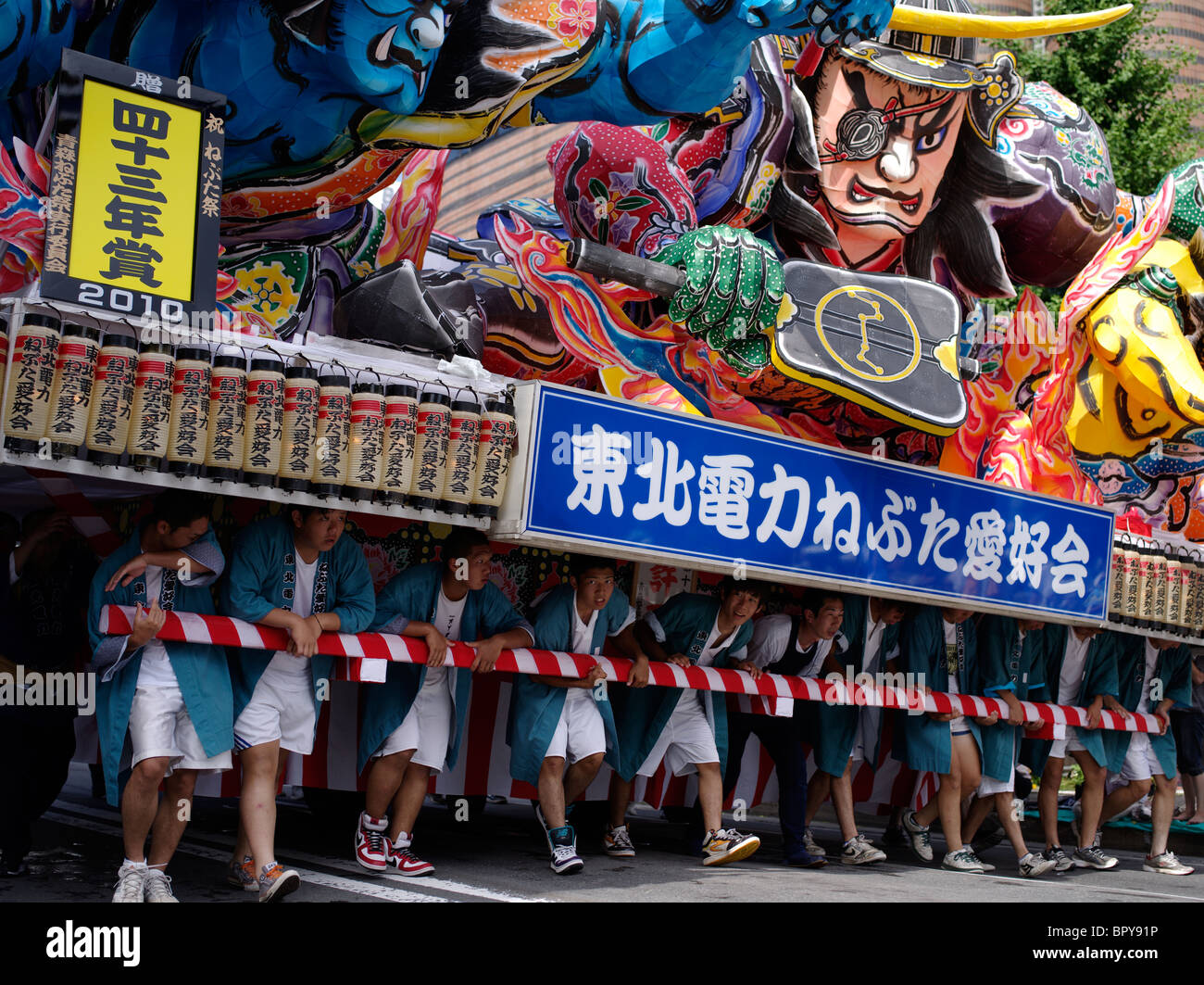 Junge japanische Männer schieben einen Schwimmer beim Nebuta Matsuri Sommerfest der riesigen hin-und Herbewegungen, Aomori City, Präfektur Aomori, Japan Stockfoto