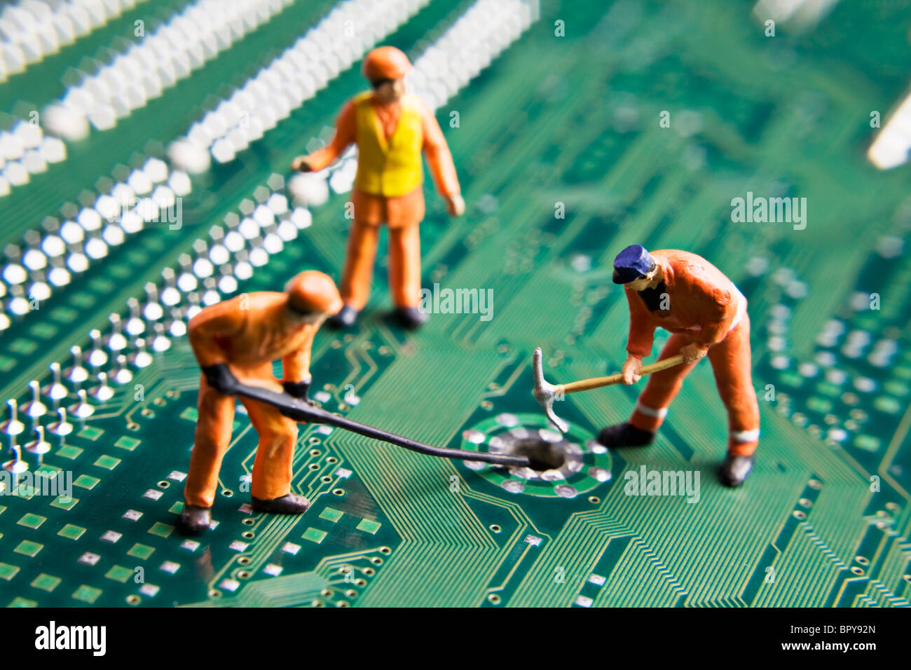 Arbeiter-Figuren auf eine Computer-Platine platziert Stockfoto