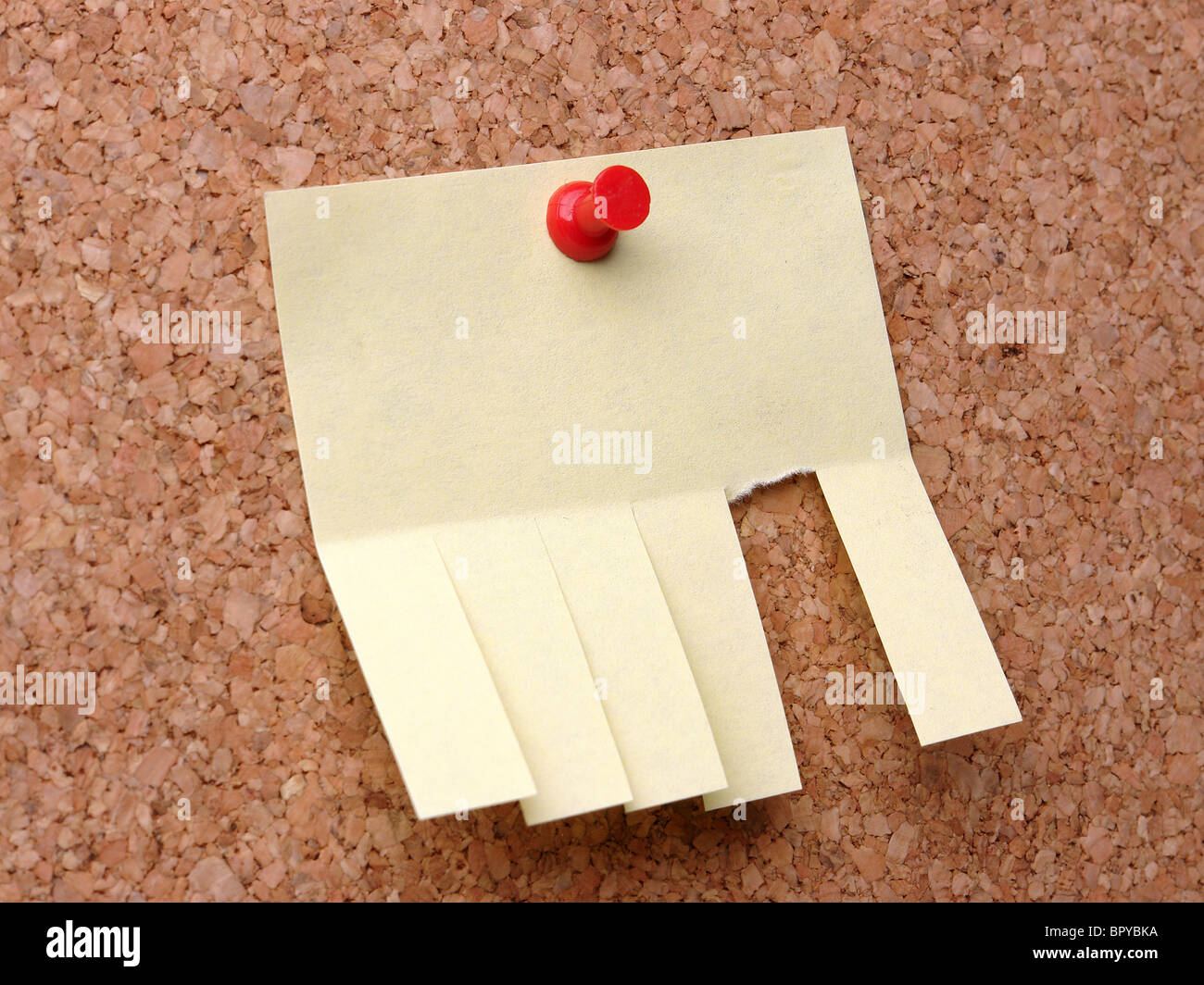 Leere gelben PostIt Zettel mit geschnittenen Slips an Pinnwand mit