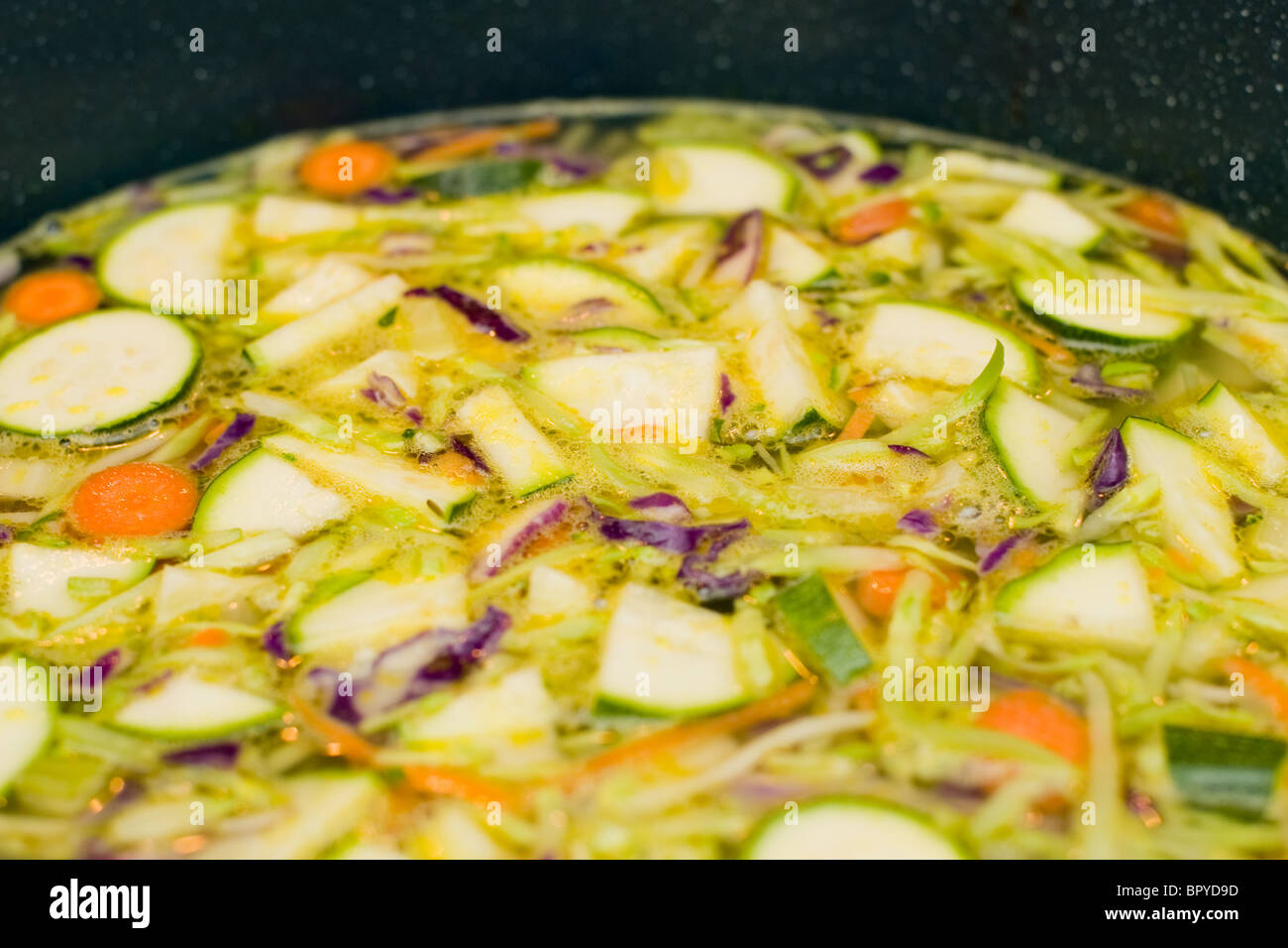 Gemüse in Hühnerbrühe kochen. Einer der Schritte bei der Herstellung hausgemachte Hühnersuppe. Stockfoto