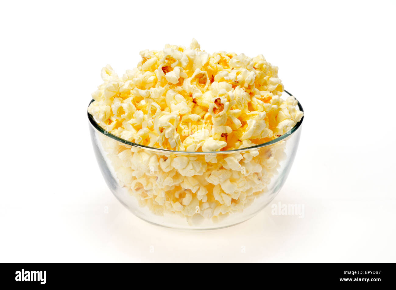 Eine Glasschüssel gefüllt mit Mikrowellen-Popcorn auf weißem Hintergrund, Ausschnitt. Stockfoto