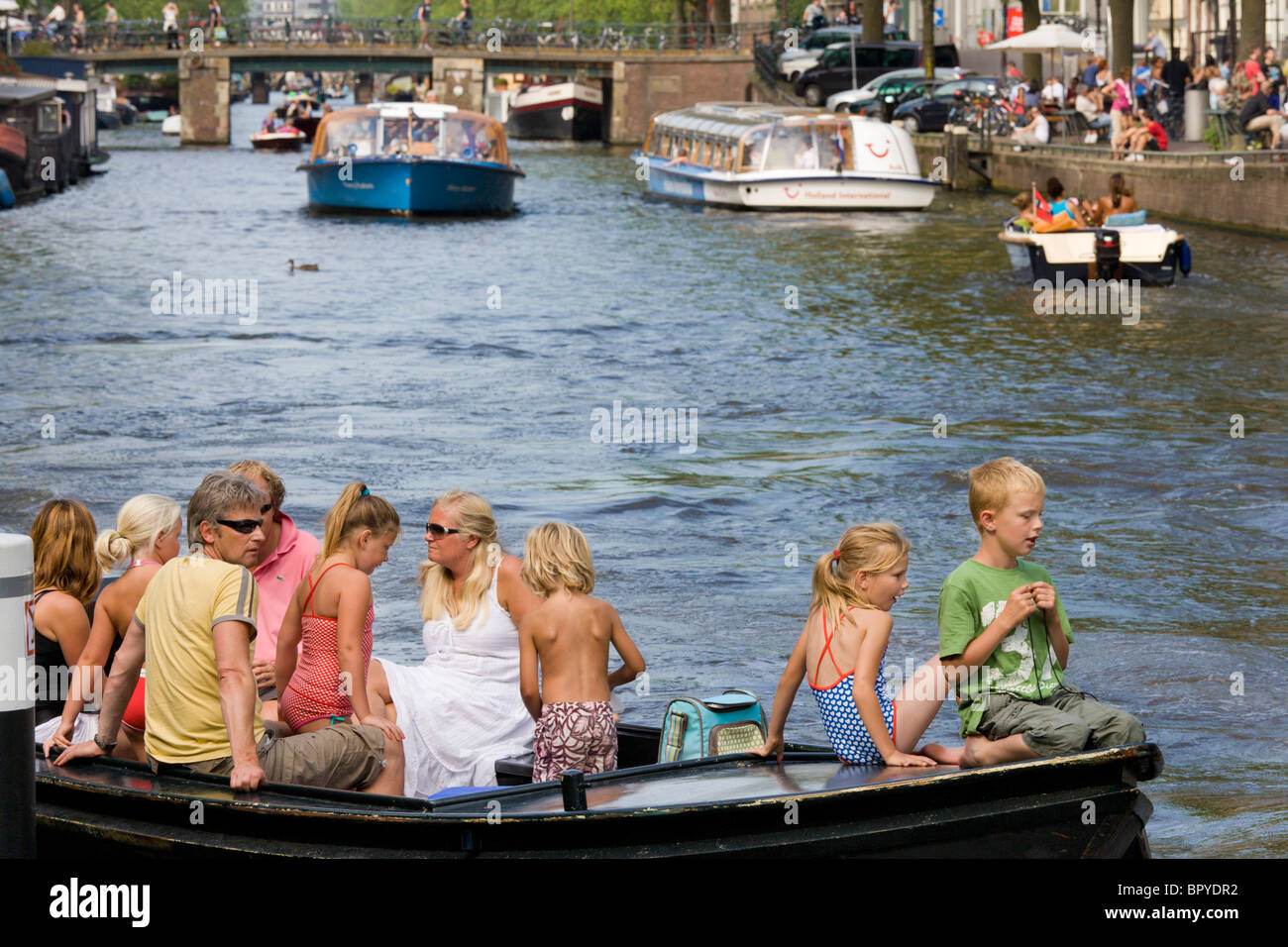 Amsterdam, Bootfahren. Familie mit Kindern in kleinen offenen Boot am Prinsengracht Kanal, mit Tour Kanalboote im Hintergrund. Stockfoto