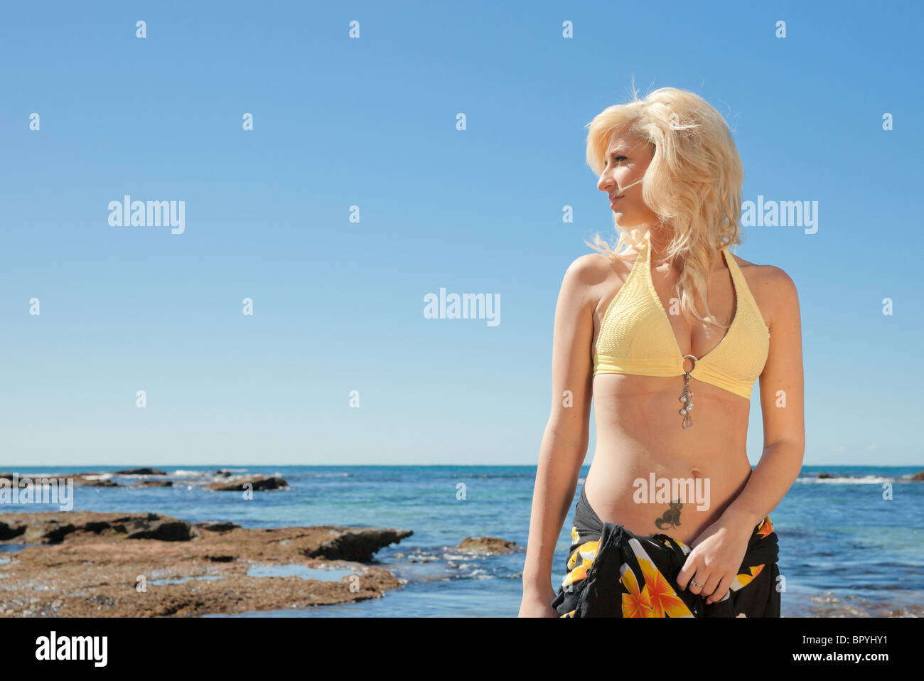 eine schöne junge blonde Frau am Strand Stockfoto