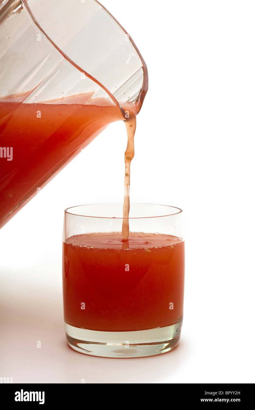 Gießen ein Glas frisch gepressten rosa Grapefruitsaft Stockfoto
