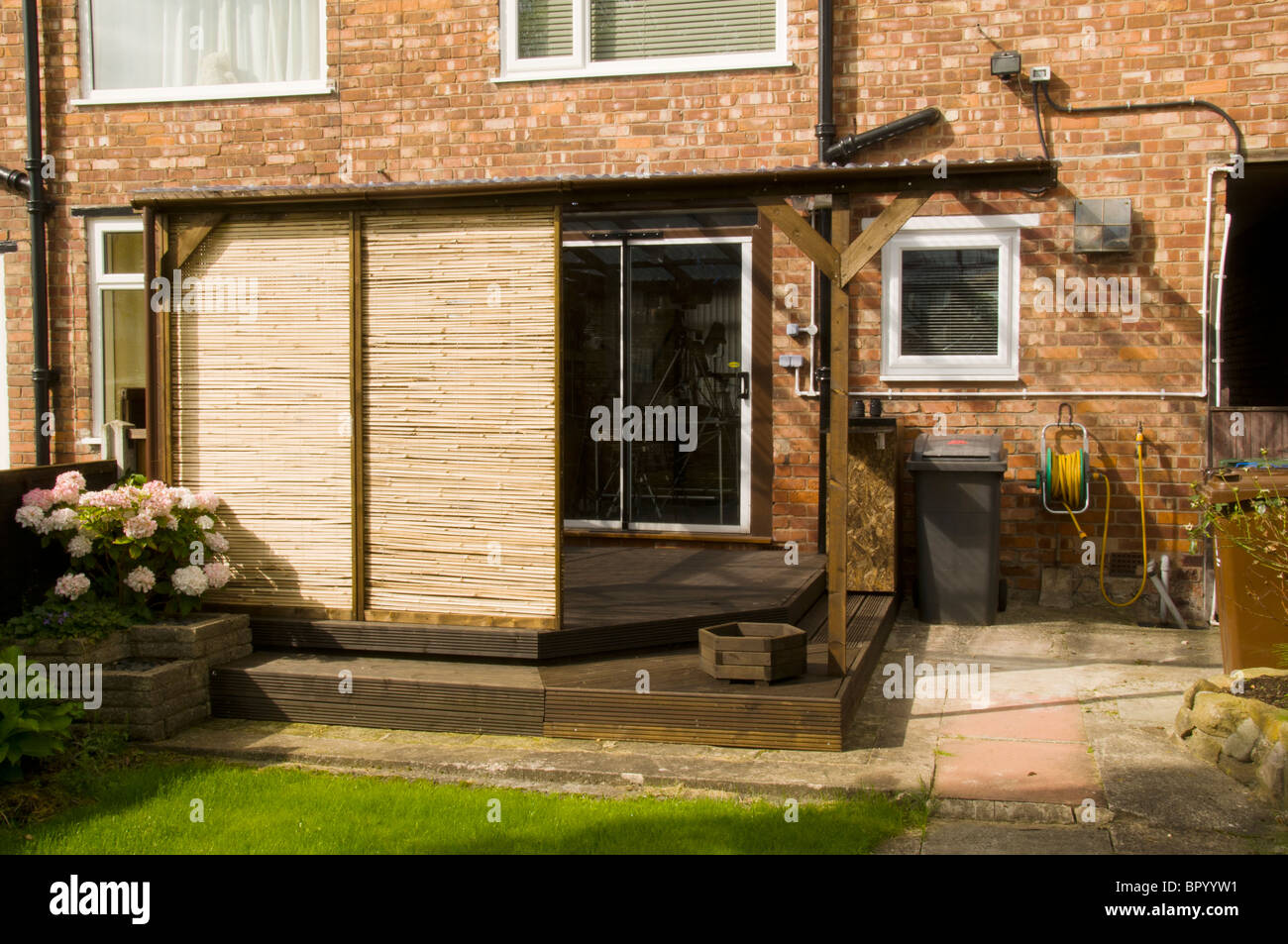 Nach Hause gebauten Terrasse Terrassendielen mit Wellpappe Kunststoff Dach und beweglicher screening-Paneele in häuslicher Umgebung.  Manchester, UK. Stockfoto