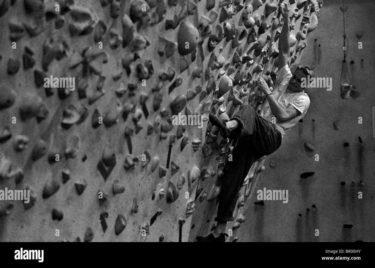 Ein Mann auf einer künstlichen Felswand klettern. Stockfoto