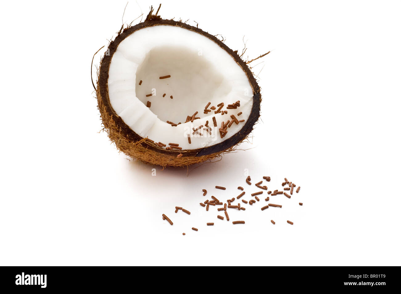 Halbierte Kokosnuss mit Schokostreuseln isoliert auf weiss Stockfoto