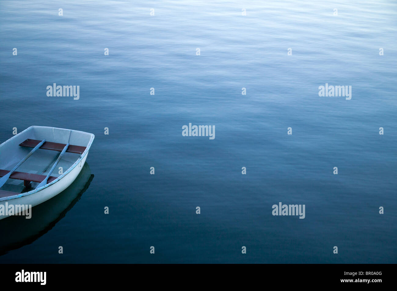 Ruderboot in ruhigem Wasser Stockfoto