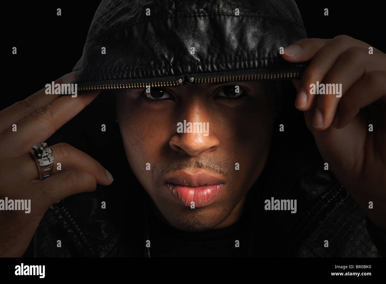 Porträt des afroamerikanischen mit Kapuze über den Kopf mit stark gerichtetes Licht Stockfoto