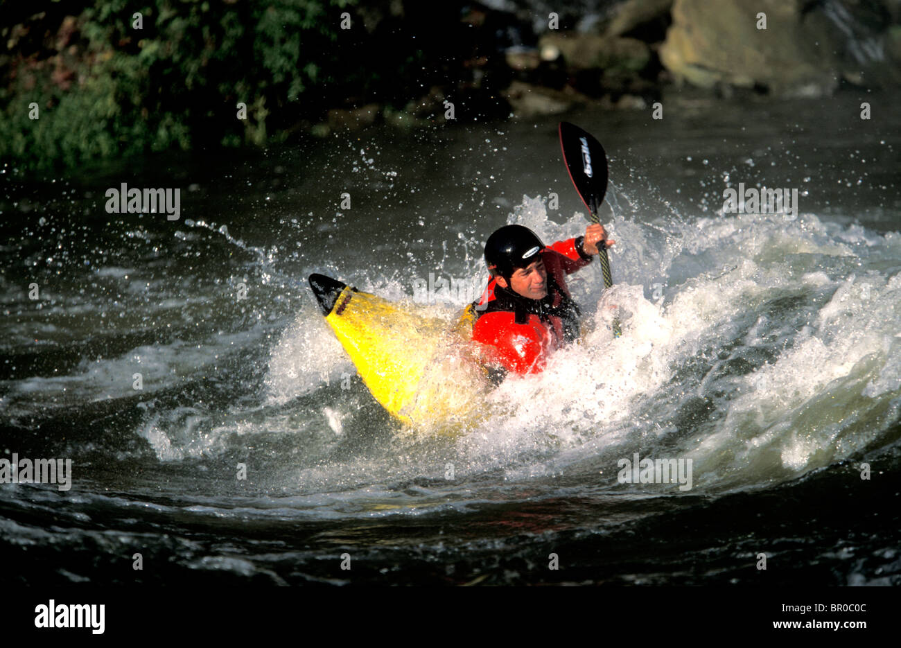 Ein Mann, ein Loch in einem Kajak Surfen. Stockfoto