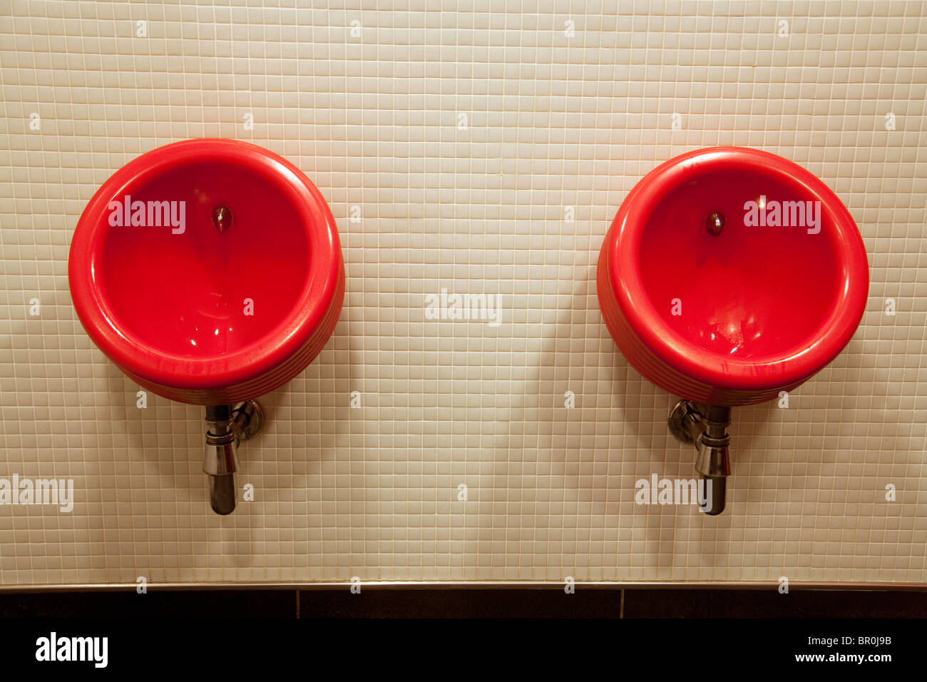 Zwei rote Urinale in den männlichen Toiletten, die Jungfrau V Raum, Gatwick Flughafen UK Stockfoto