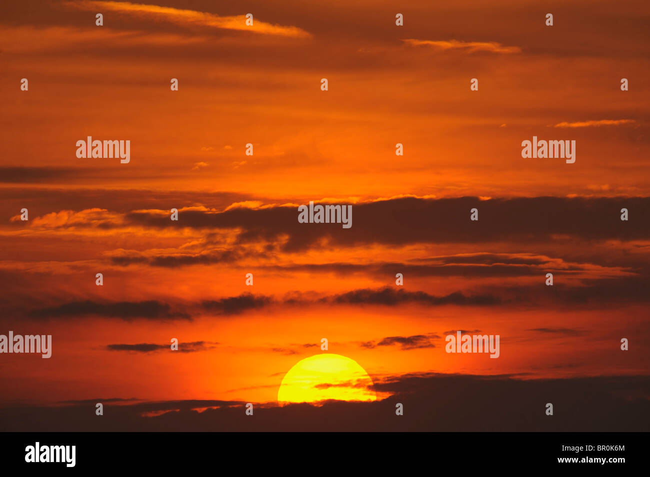 eine feurige Sonne mit einem orangefarbenen Himmel-Querformat Stockfoto