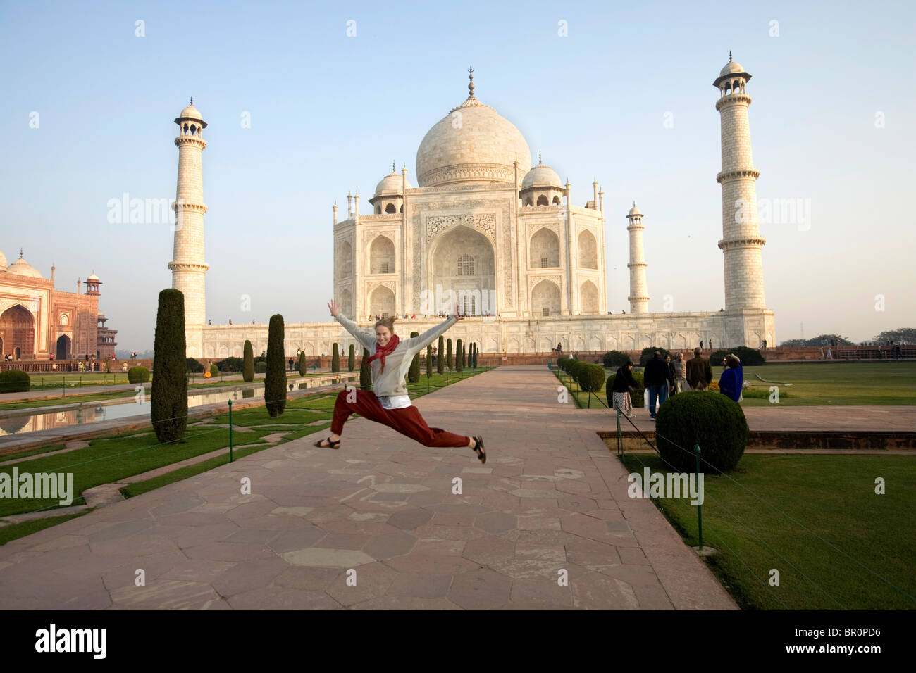 Westliche Mädchen springen für Fummy Erinnerungsfoto aus dem Taj Mahal, Agra, Uttar Pradesh, Indien. Stockfoto