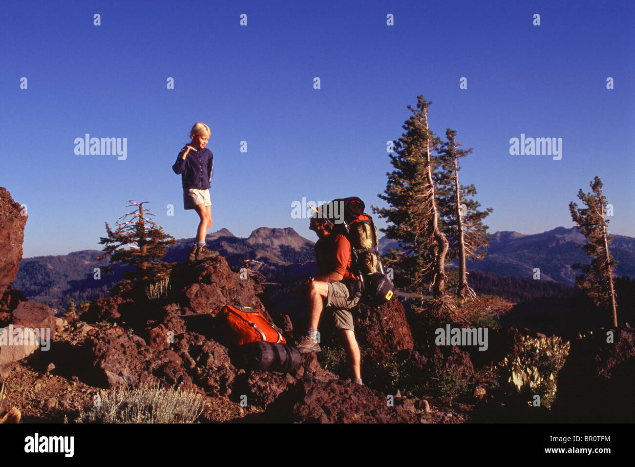Ein Mädchen klettern einen Felsen mit ihrem Vater in der Sierra Mouintains von Kalifornien. Stockfoto