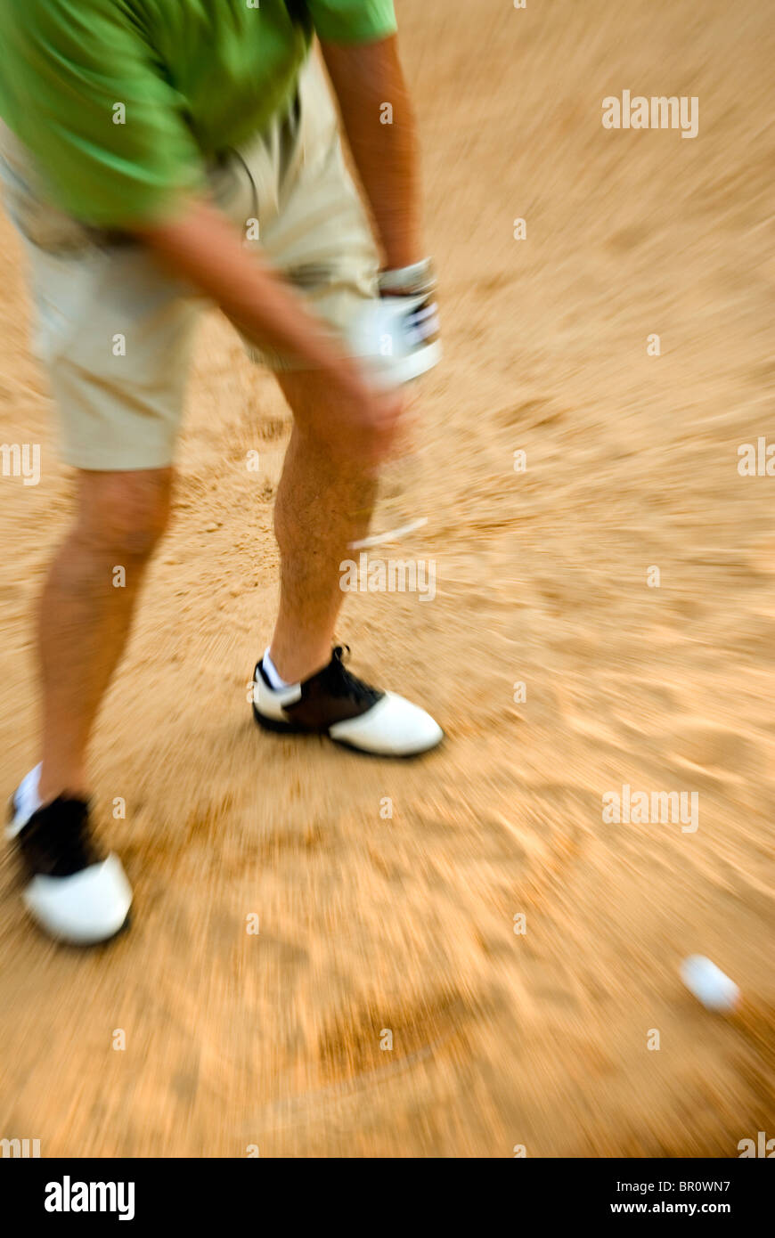 Ein Mann schlägt einen Golfball aus einem Sandfang in Georgien. Stockfoto