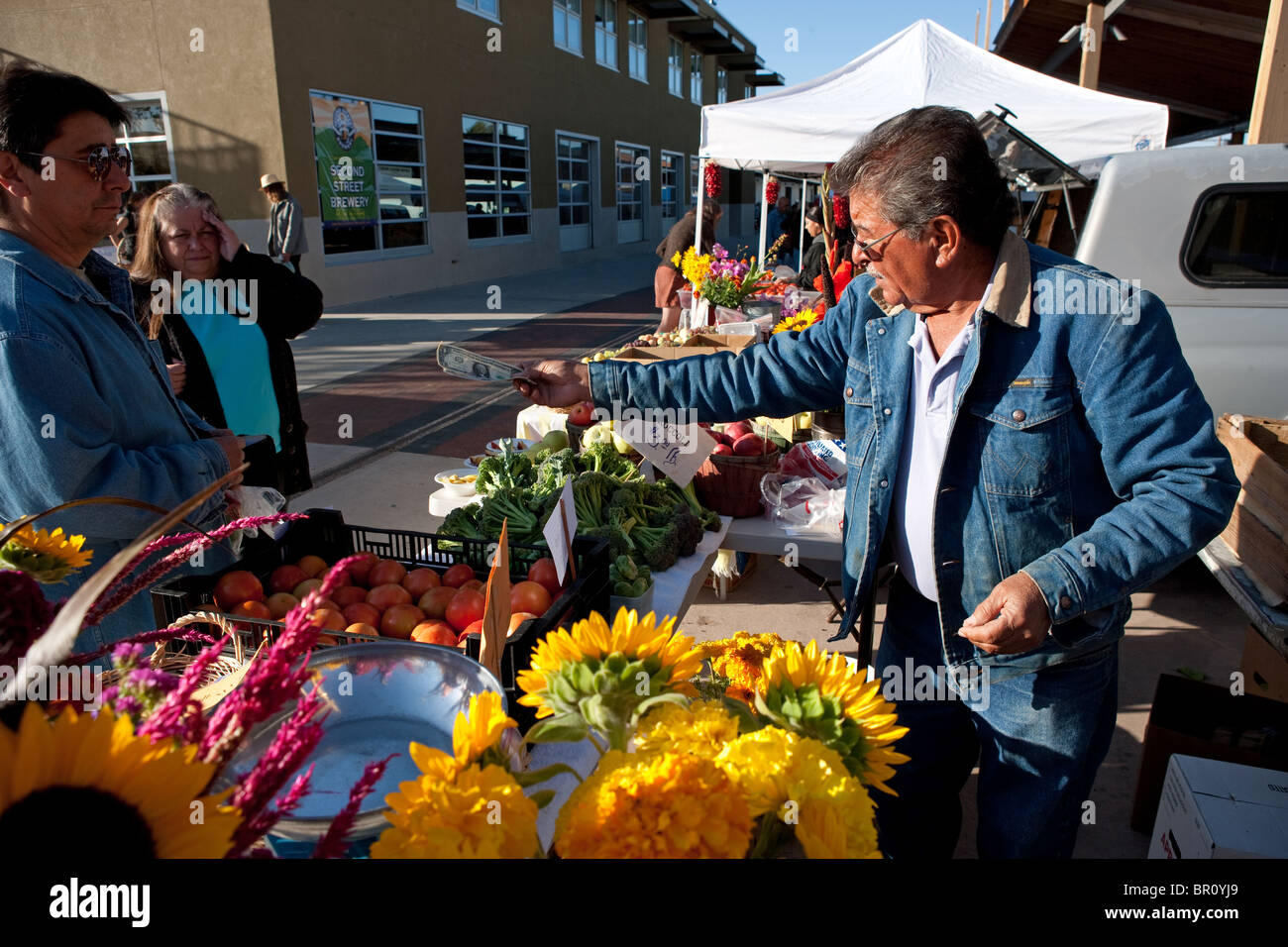 Bauer, Sonnenblumen und Gemüse im Santa Fe Markt, Hände Kunde seinen Wechsel zu verkaufen, Stockfoto