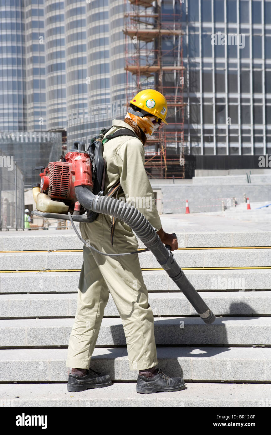 Ein Arbeiter ist die Treppe mit einem Maching welche Pracht auf einer Baustelle des Burj Khalifa in Dubai Luftreinigung. Stockfoto