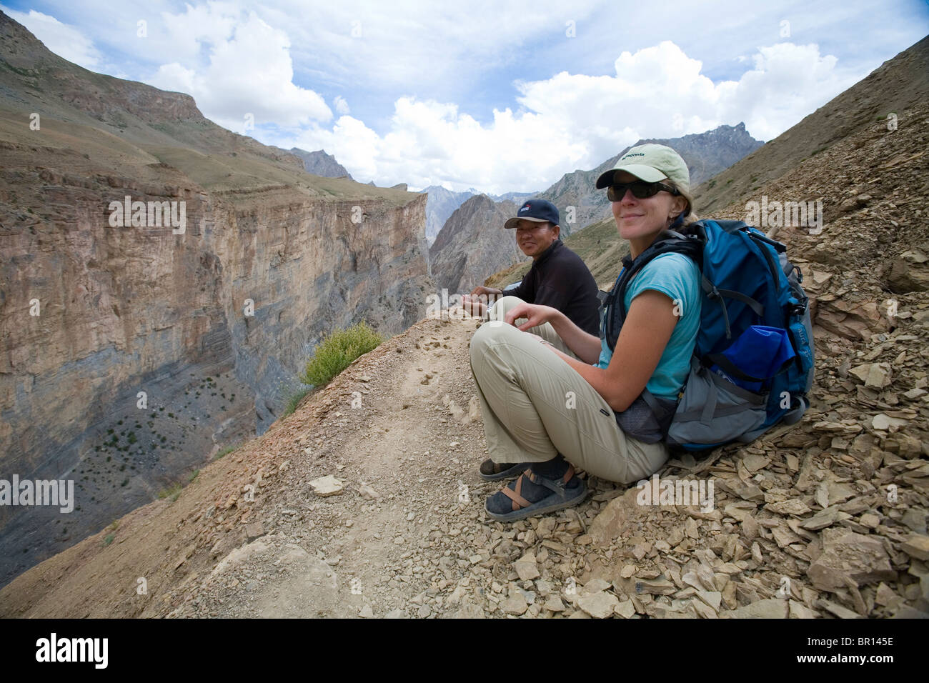 Frau Trekker und Guide ruhen auf Trail in robusten und trocknen Zanskar Gebirge im Norden Indiens während der Wanderung. Stockfoto