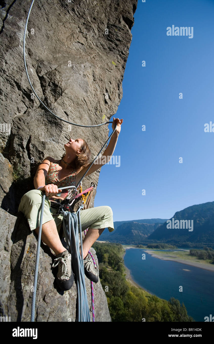 Eine attraktive junge Frau belays Felskletterer aus Klippe im Columbia River Gorge an der Washington Oregon Grenze an sonnigen Tag. Stockfoto