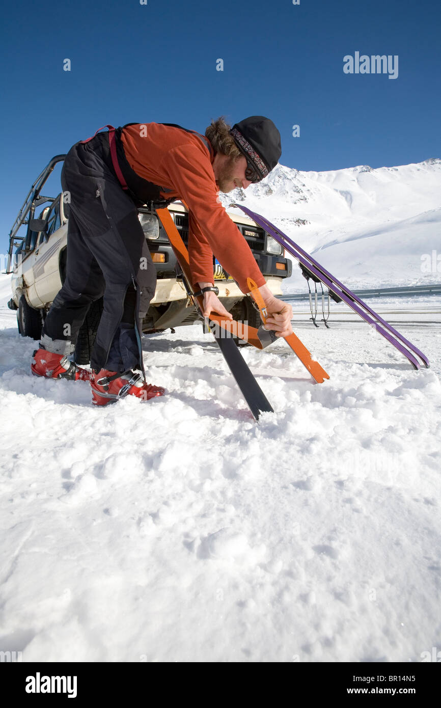 Mann legt Klettern Skins auf Skiern neben Straße im Yukon Territorium, Kanada Stockfoto