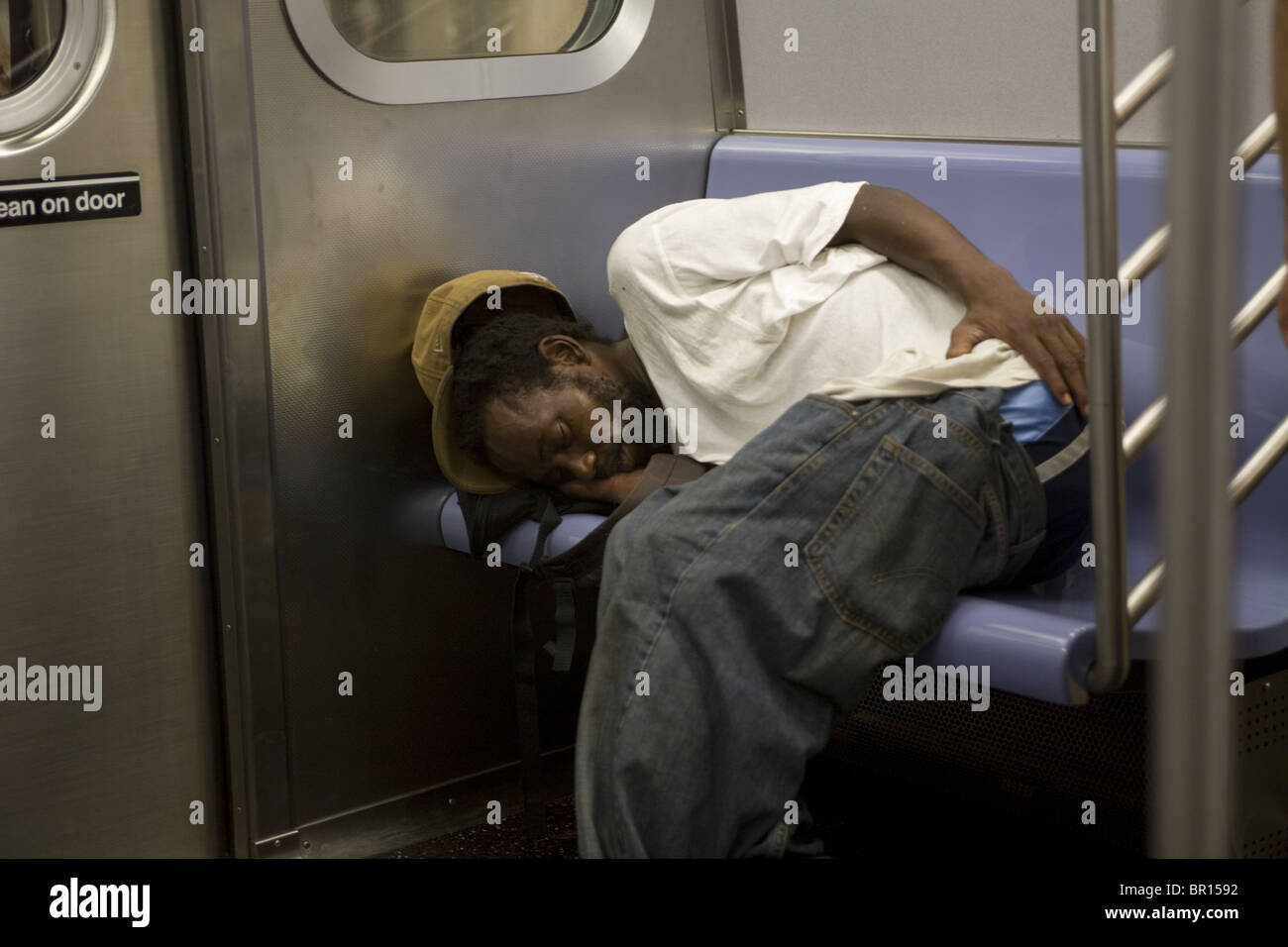 Mann schläft auf einer New Yorker u-Bahn. Stockfoto