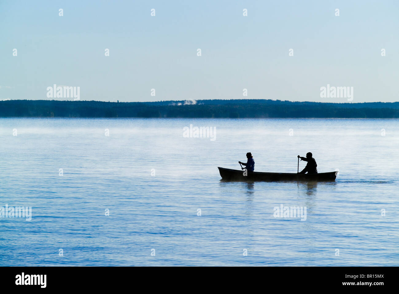 Eine Kanu lagen die Gewässer im Morgennebel von Sebago See in Maine. Stockfoto
