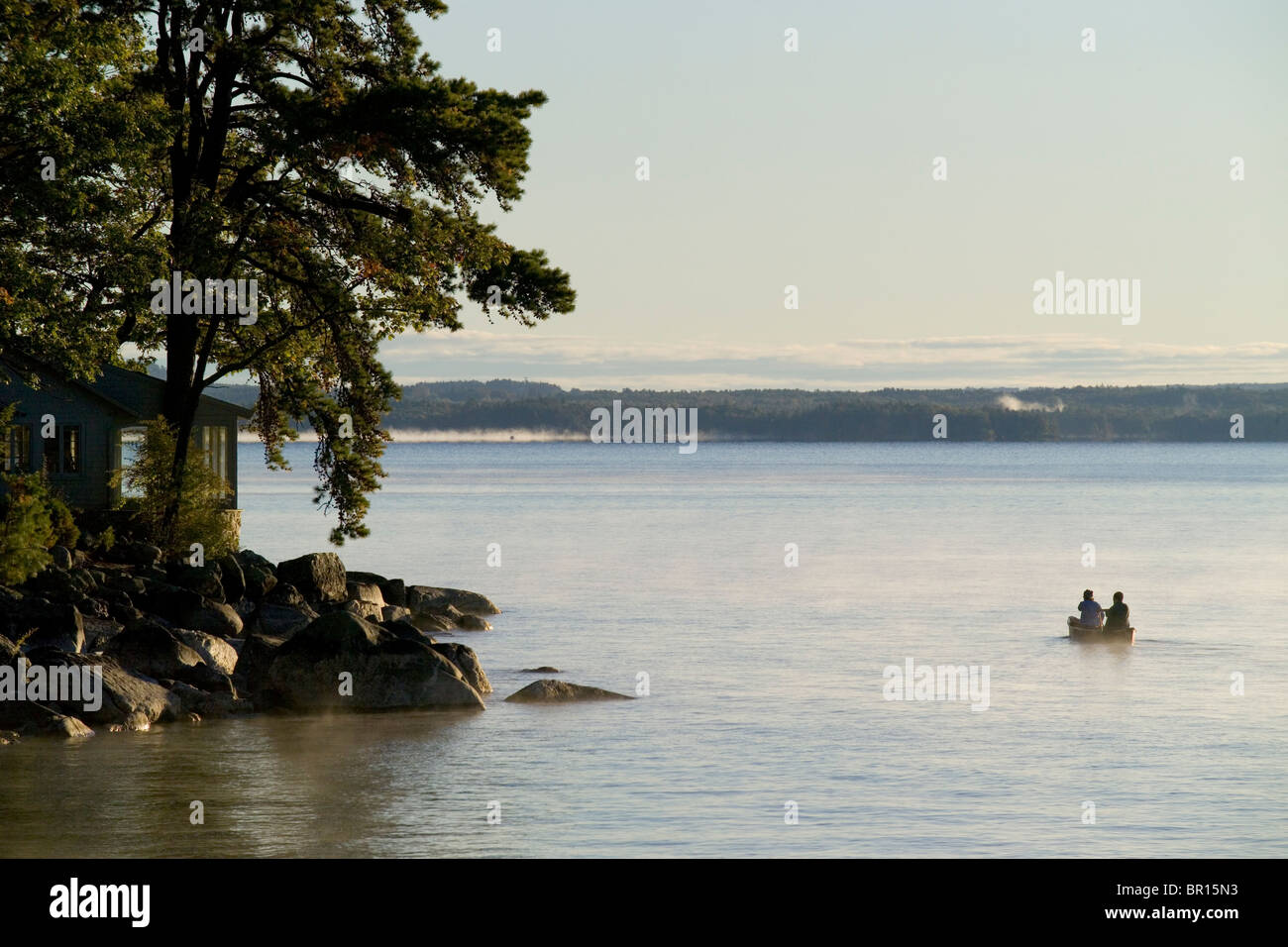 Eine Kanu lagen die Gewässer im Morgennebel von Sebago See in Maine. Stockfoto