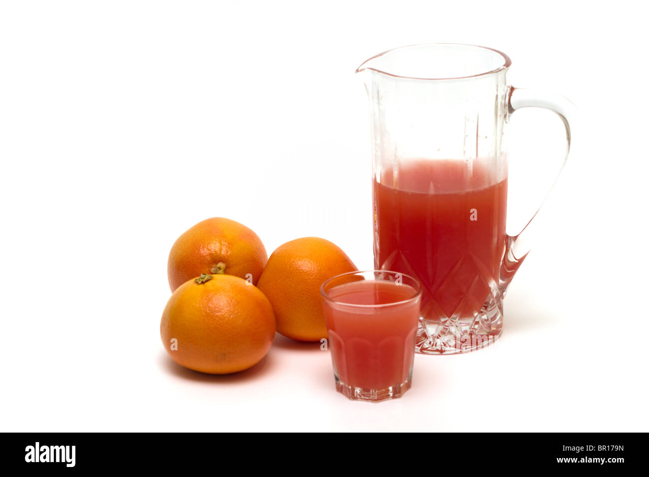 Grapefruits mit einem Krug und Glas frisch gepresster Grapefruitsaft Stockfoto
