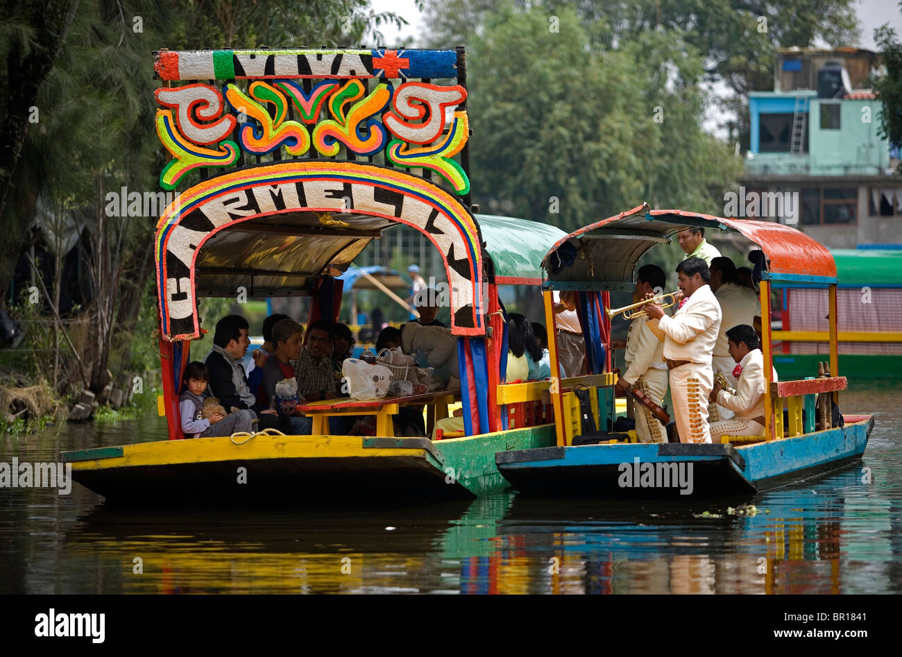 Mariachi Musiker spielen mexikanische Lieder für Touristen in einem Boot durch die Wasserkanäle von Xochimilco auf der Südseite von Mexiko C Stockfoto