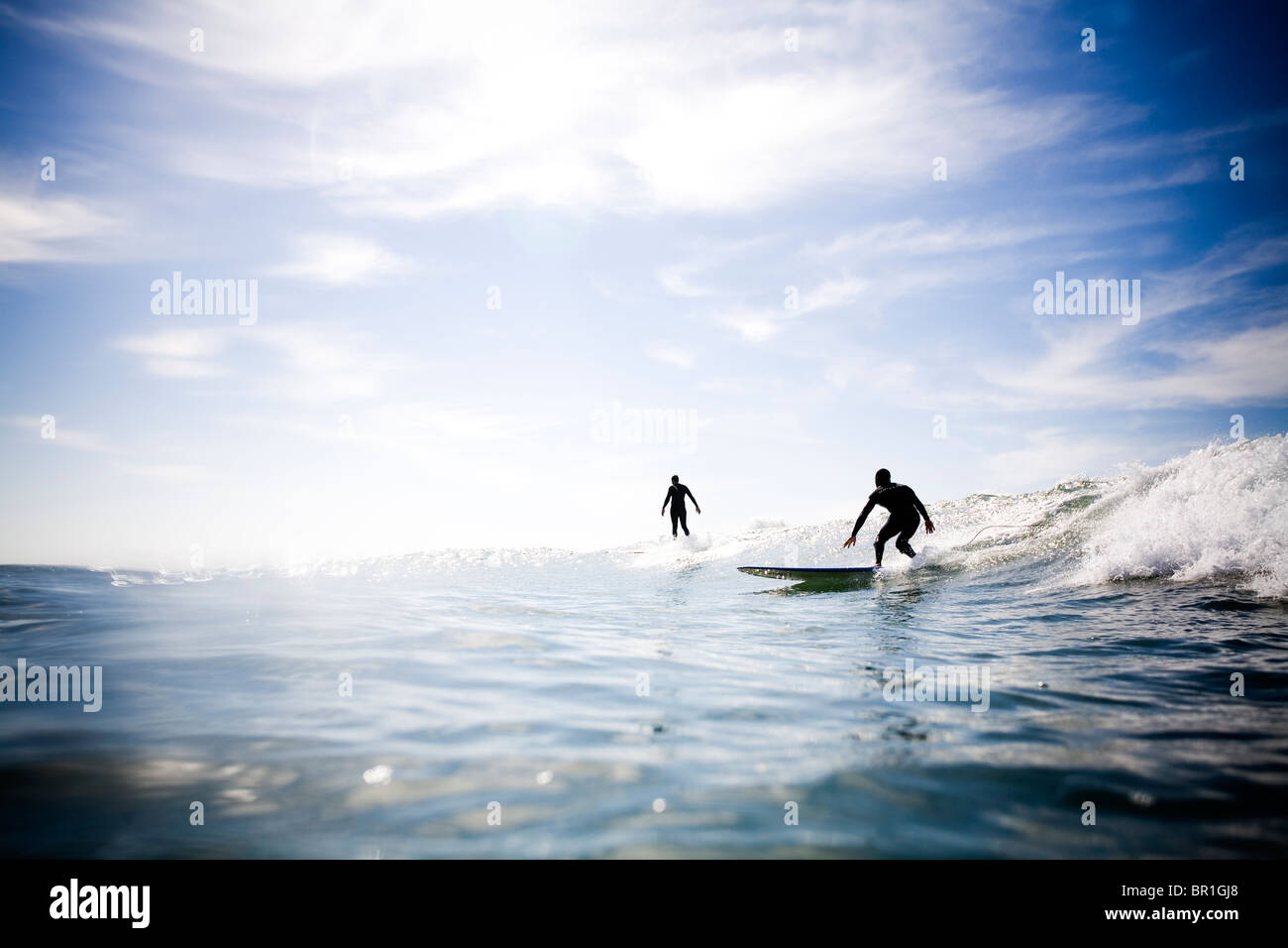 Zwei beleuchtete Surfer abnehmen auf einer Welle. Stockfoto