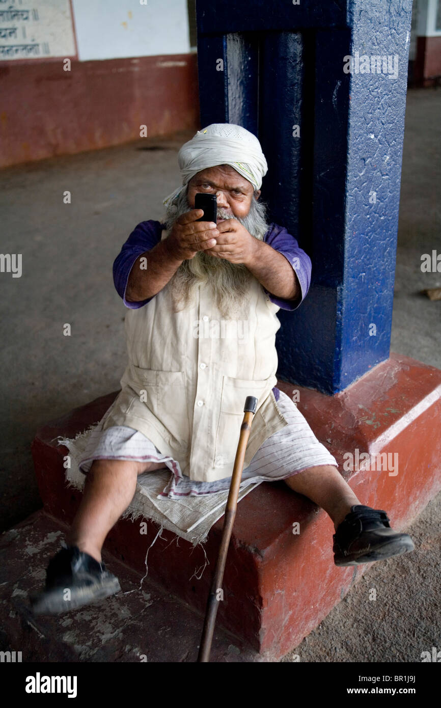Hindu Zwerg unter Bild mit einem Mobiltelefon, Naugarh Bahnhof, Siddharthnagar, Uttar Pradesh, Indien, Asien. Stockfoto