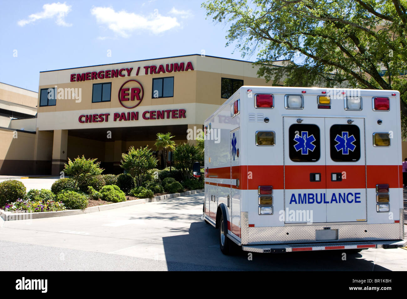 Ein Krankenwagen zieht in ein modernes Krankenhaus-Notaufnahme-Eingang. Stockfoto