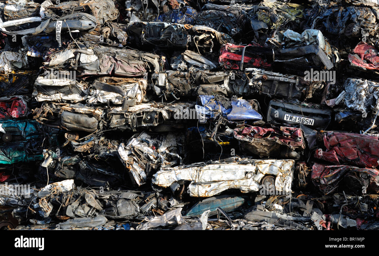 Ein großer Haufen zerstoßener Schrottwagen wartet auf die Abholung am Hafen, bevor sie recycelt werden. Stockfoto