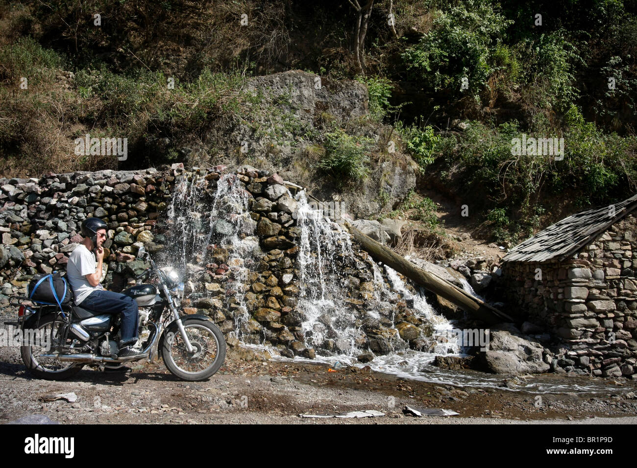 Ein Mann sitzt auf einem Royal Enfield 'Bullet' Motorrad während einer Motorradtour im Himalaya in Himachal Pradesh in Indien Stockfoto