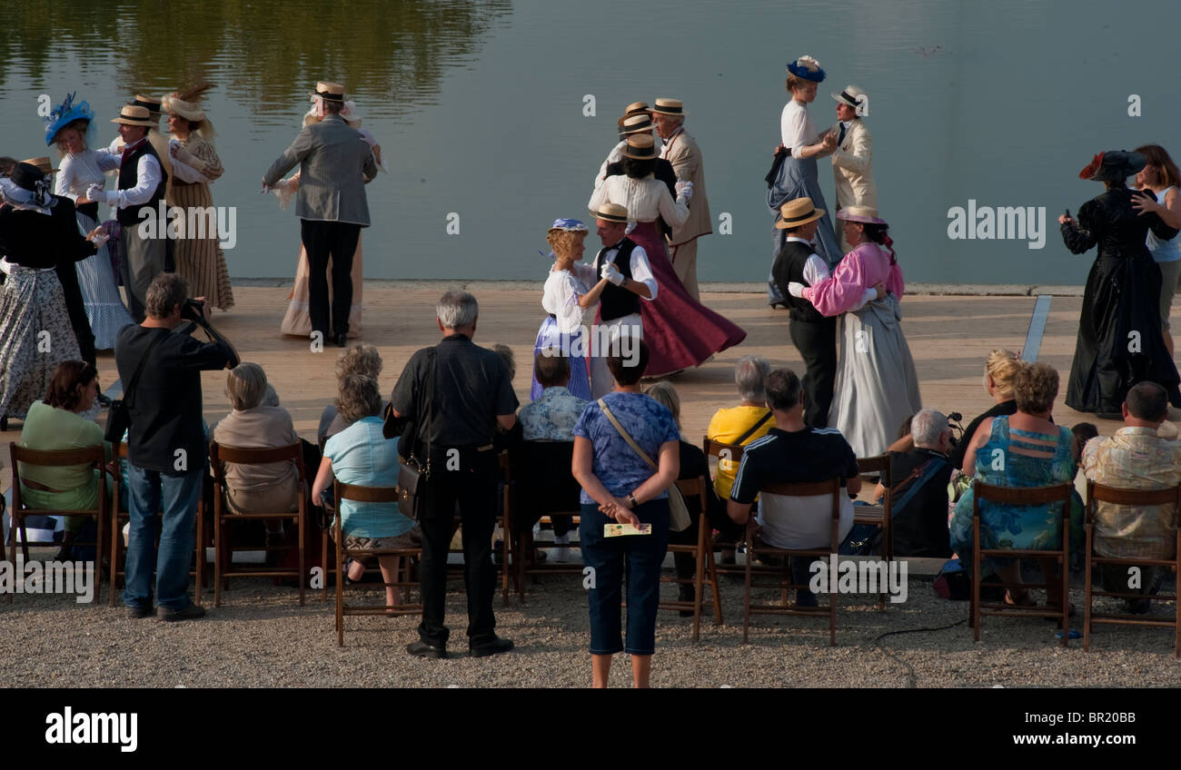 France - High Angle, Crowd Adults Dancing Outdoors near Pond, Chateau de Breteuil, Choisel, Seniors Dressed in Period Costume, Rear view of group of seniors, Retro holiday ballroom dancing Stockfoto