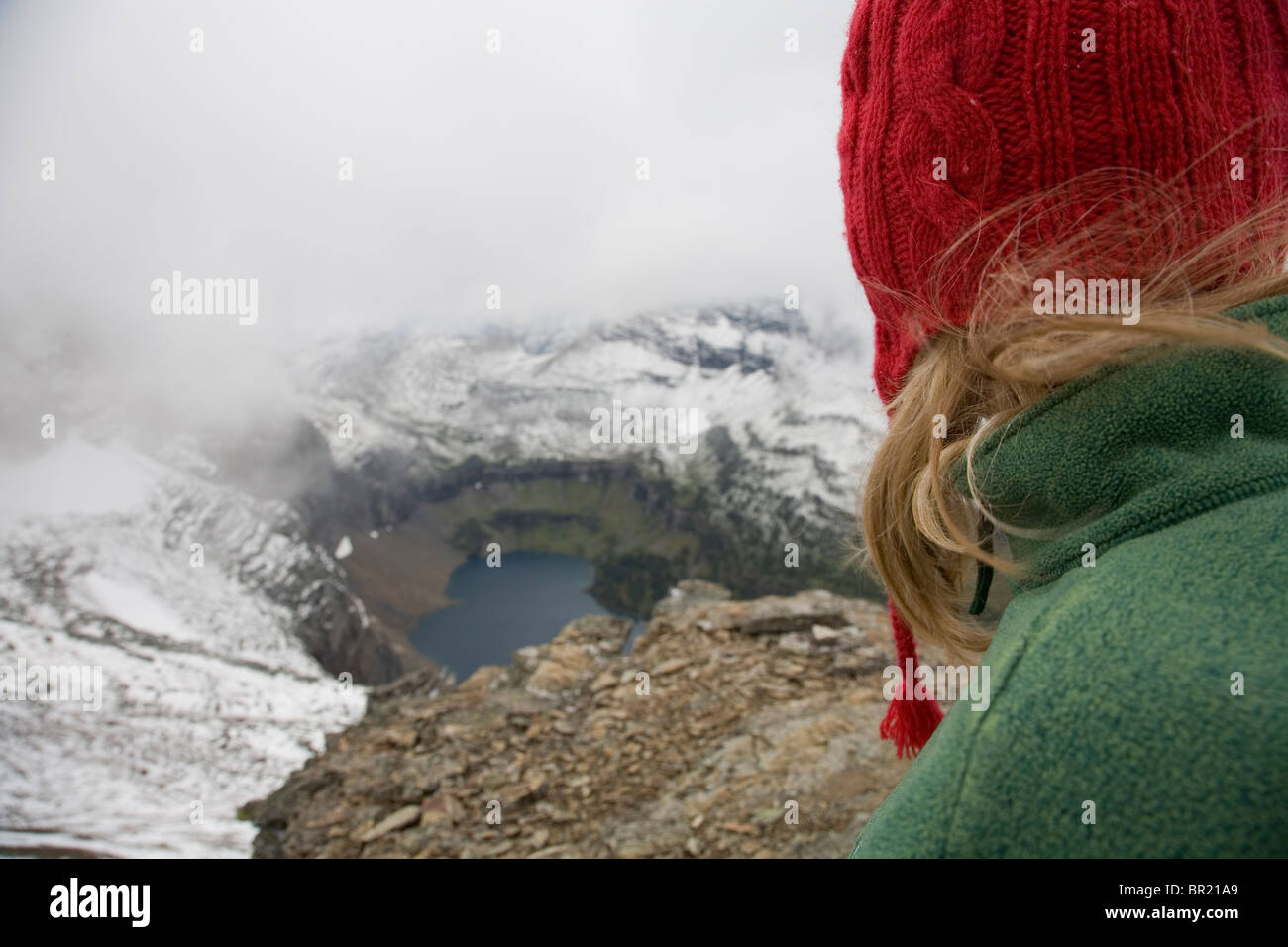 Ein Bergsteiger im Glacier National Park schaut auf verborgenen See als Sommer-Schnee-Sturm in den Bereich bewegt. Stockfoto