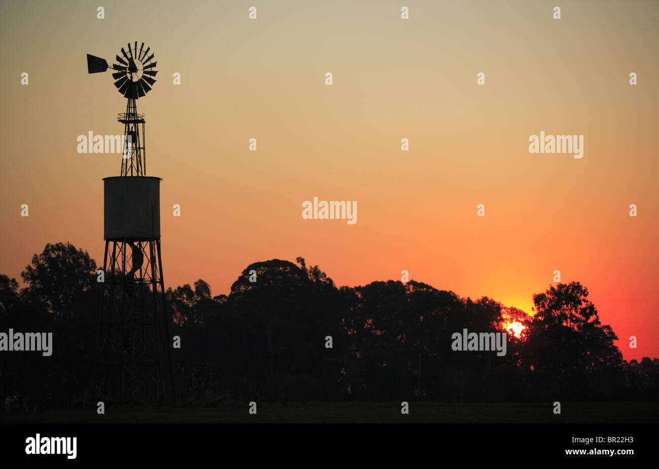 Eine Windmühle bei Sonnenuntergang auf einer Ranch in Argentinien Stockfoto