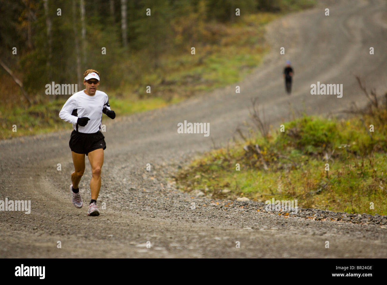 Mann, einen Marathon zu laufen, auf einem Schotterweg in der Nähe von Anchorage, Alaska. Stockfoto