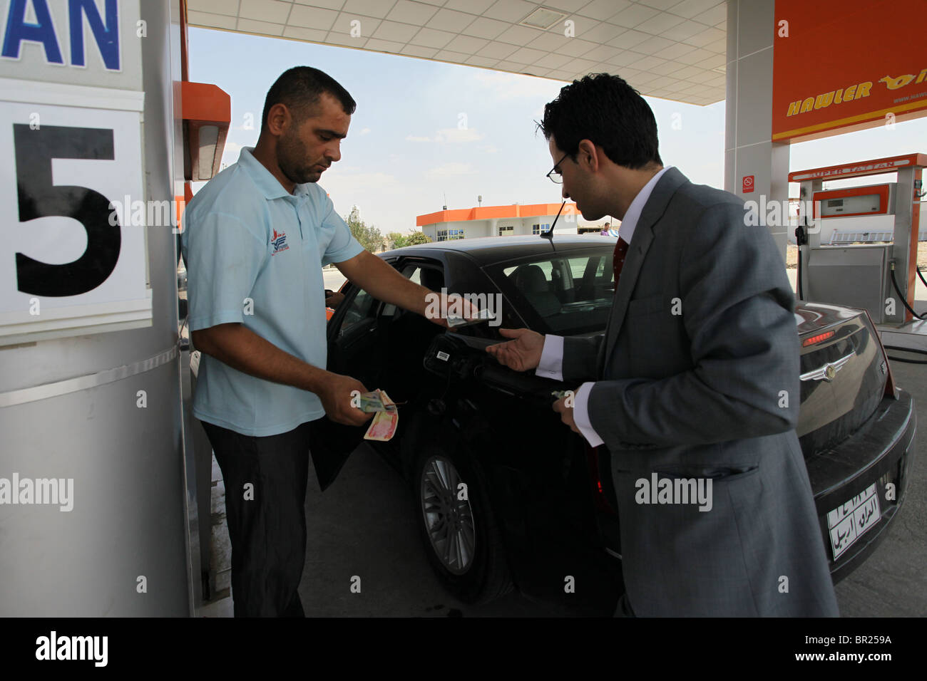 Kurdische Mann tanken sein Auto mit Benzin an einer Tankstelle von Benzin aus dem Hawler Lizenz Bereich in der Region Kurdistan im Irak gepumpt ("Kri"). Summe der durchschnittlichen täglichen Erdölförderung aus der Hawler Lizenz Bereich für Oryx Petroleum ist etwa 5.300 Barrel pro Tag. Stockfoto